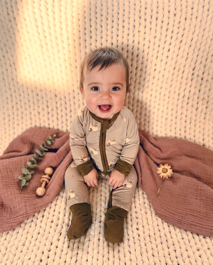 Stella wearing The Lila — convertible zip footie in warm taupe with watercolor cat print
